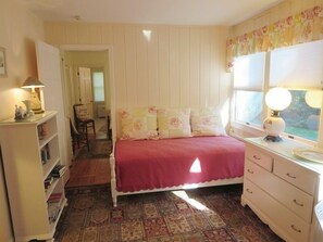 A bedroom with a bed, a dresser, a nightstand, a lamp, and a window. - Chatham Ranch Retreat Near Hardings Beach (Chatham)
