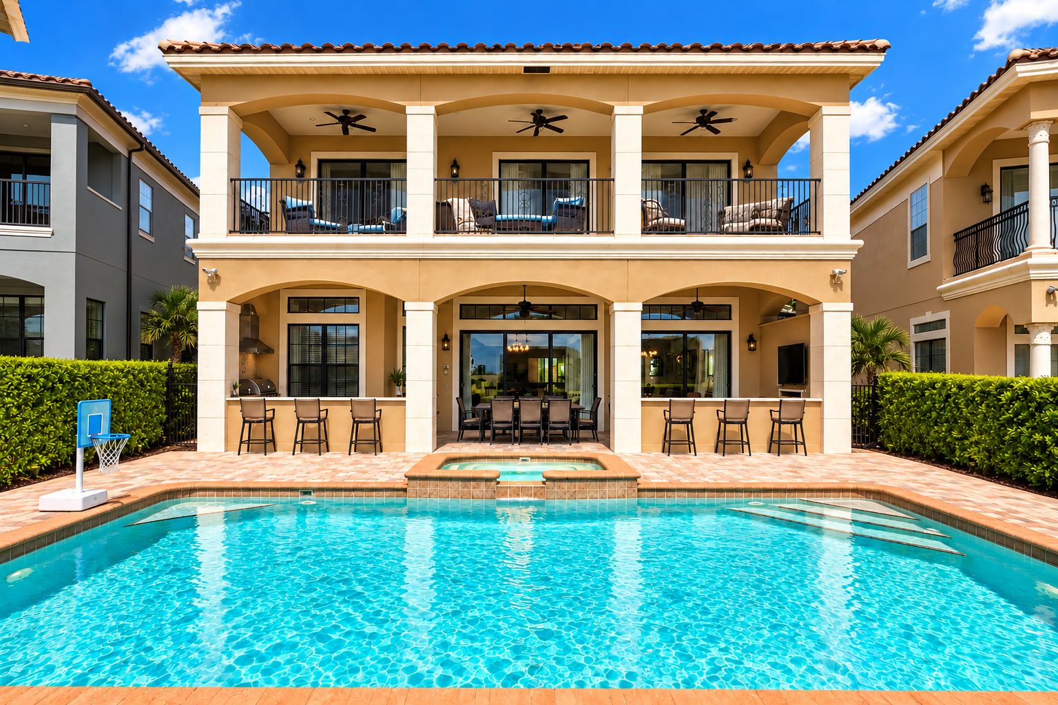 A two-story building with a swimming pool, outdoor seating, and a patio area.