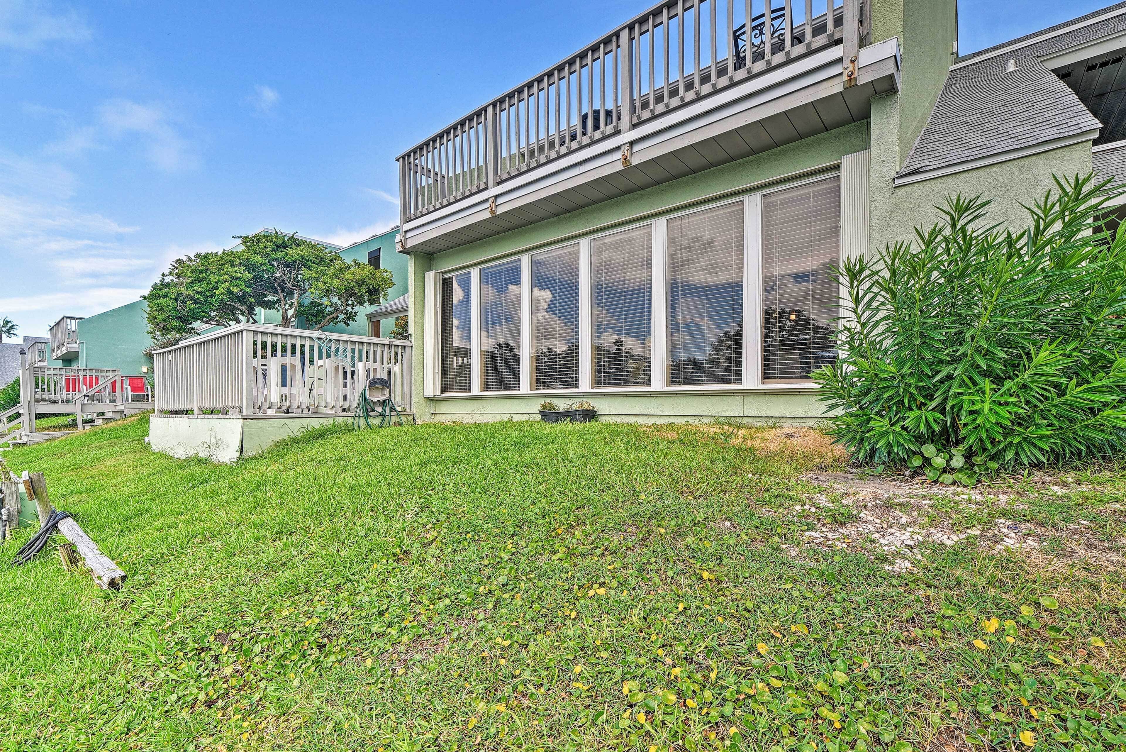 A two-story house with a large front porch and a covered patio area.