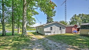 A single-story house with a garage, a small shed, and a dock by a lake. - 2 Mi to Boat Ramp! Family Cabin on Long Lake (Hale)
