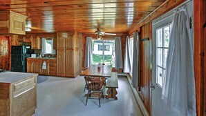 A cabin-style kitchen with wooden cabinets, a dining table, and a bench. - 2 Mi to Boat Ramp! Family Cabin on Long Lake (Hale)
