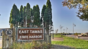 Skilt for East Tawas State Harbor med natur i baggrunden.