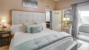 A bedroom with a large bed, a ceiling fan, a bedside table with a lamp, and a view of the outside. - Dog-Friendly Tucson Home w/ Patio & Hot Tub (Tucson)
