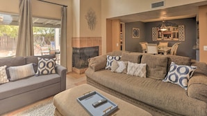 A spacious living room with a large sofa set, a fireplace, and a dining area. - Dog-Friendly Tucson Home w/ Patio & Hot Tub (Tucson)