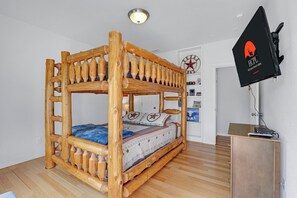 A bunk bed with a wooden frame and a television mounted on the wall. - Rio Cantando I Blanco River, Pool, Hot Tub, Game Room (Wimberley)