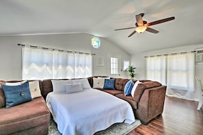 A cozy living room with a large sectional sofa, a bed, and a ceiling fan. - Beachy Lavallette Cottage w/ Outdoor Shower, Patio (Lavallette)