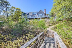A house with a wooden deck and a pathway leading to it.