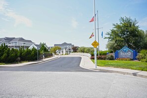 A residential street with a 'NO OUTLET' sign, a flagpole with flags, and a sign for 'The Island at Ridgemont Harbour'. - Large, spacious 3 bedroom condo with free WiFi, a boat slip, and an outdoor pool located uptown on the bay water with breathtaking view of bay! (Ocean City)