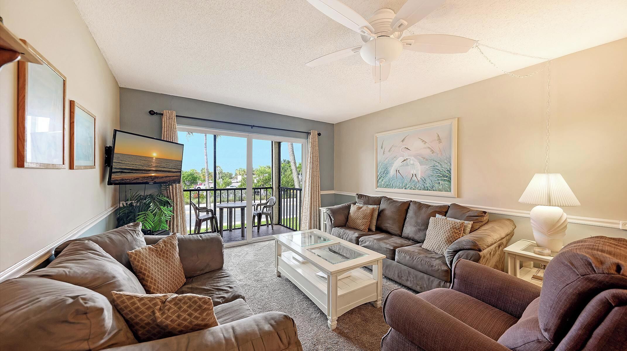 A living room with a sofa set, a coffee table, a TV, and a painting on the wall.