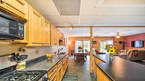 Una cocina moderna con armarios de madera, estufa a gas y microondas.