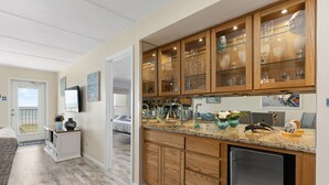 A modern kitchen with wooden cabinets, a granite countertop, and a built-in dishwasher.