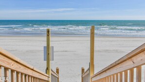 A wooden beach boardwalk leading to the ocean with a clear view of the sea. - Krabby Patty – Oceanfront Family Fun (Topsail Beach)