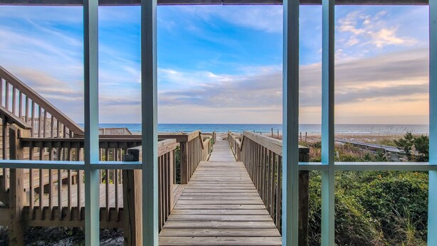 A wooden boardwalk leading to a beach with a clear sky. - Krabby Patty – Oceanfront Family Fun (Topsail Beach)