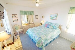 Ein Schlafzimmer mit Bett, Stuhl, Schminktisch und Schreibtisch.