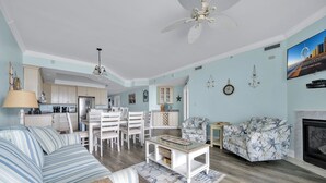 Ein geräumiges Wohnzimmer mit einer Couch, einem gemusterten Sessel, einem Couchtisch und einem Kamin.