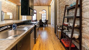 Una cocina moderna con techo de madera, paredes de piedra y una isla central.