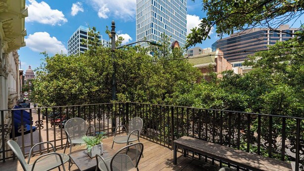 An outdoor patio with a wooden deck, metal chairs, a table, and a bench. - Luxury Stay | Views, Game Room & Chef’s Kitchen (Austin)