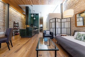 A modern interior with a wooden ceiling, a glass coffee table, a sofa, and a bed. - Luxury Stay | Views, Game Room & Chef’s Kitchen (Austin)
