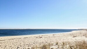 A beach with a clear sky and calm sea.