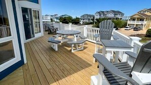 A wooden deck with outdoor seating and a view of neighboring houses. - WH888- Beautiful! With 4 BRs (2 Masters), Private Pool, Hot Tub & Wet Bar! (Corolla)