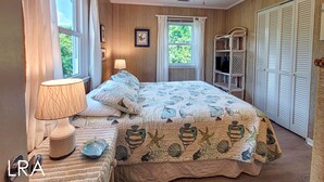 A bedroom with a bed, a ceiling fan, a window, a lamp, and a wardrobe. - Merri Mac – Breezy Stays by the Sea (Surf City)