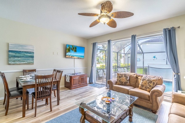 Living Area Features Easy Access To The Pool Area, A Large Wall Mounted Flat Screen TV