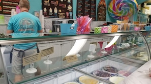 A dessert display with various ice cream flavors and waffle cones.