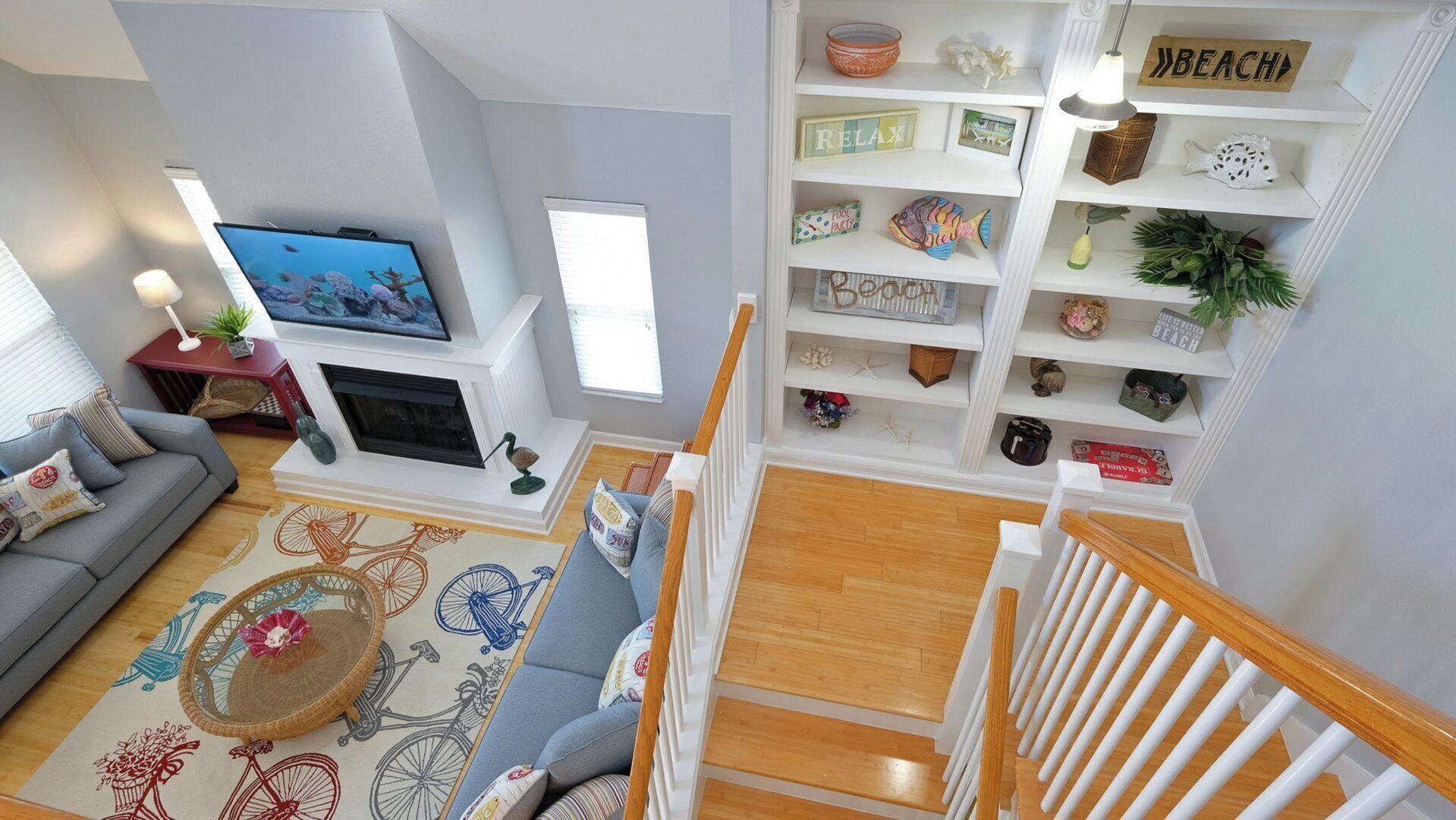 A living room with a TV, sofa, and a staircase leading to a second floor.
