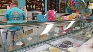 Un présentoir de desserts avec différentes sortes de glaces et des cornets.