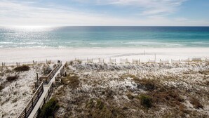 A beach with a wooden boardwalk leading to the shore, sandy dunes, and a clear view of the ocean. - GD 504 Emerald Sea Oasis: Wake Up to Breathtaking Ocean Views (Fort Walton Beach)