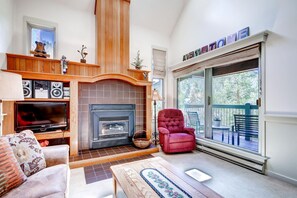 A cozy living room with a fireplace, a television, and a comfortable seating area. - Hot Tub & Grilling Area: Keystone Townhome! (Keystone)