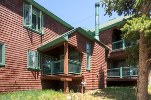 Un edificio de madera rojo con detalles verdes y una chimenea.
