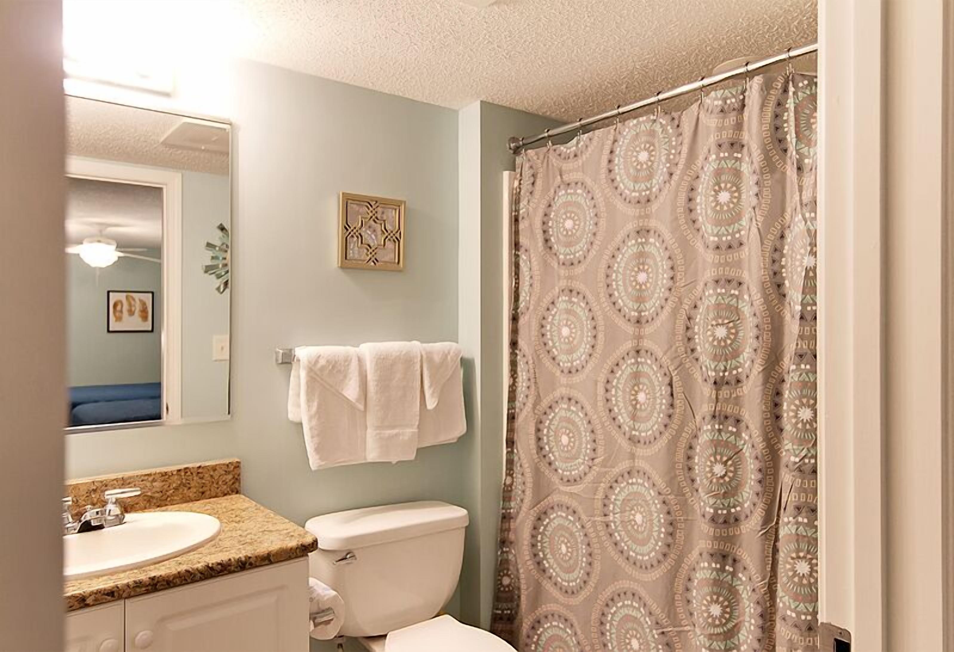 Un baño con lavabo, inodoro y cortina de ducha.