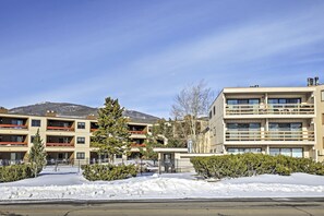 A multi-story building with balconies, a parking lot, and snow-covered ground. - Mtn-View Condo w/ Hot Tub Access in Dillon! (Dillon)