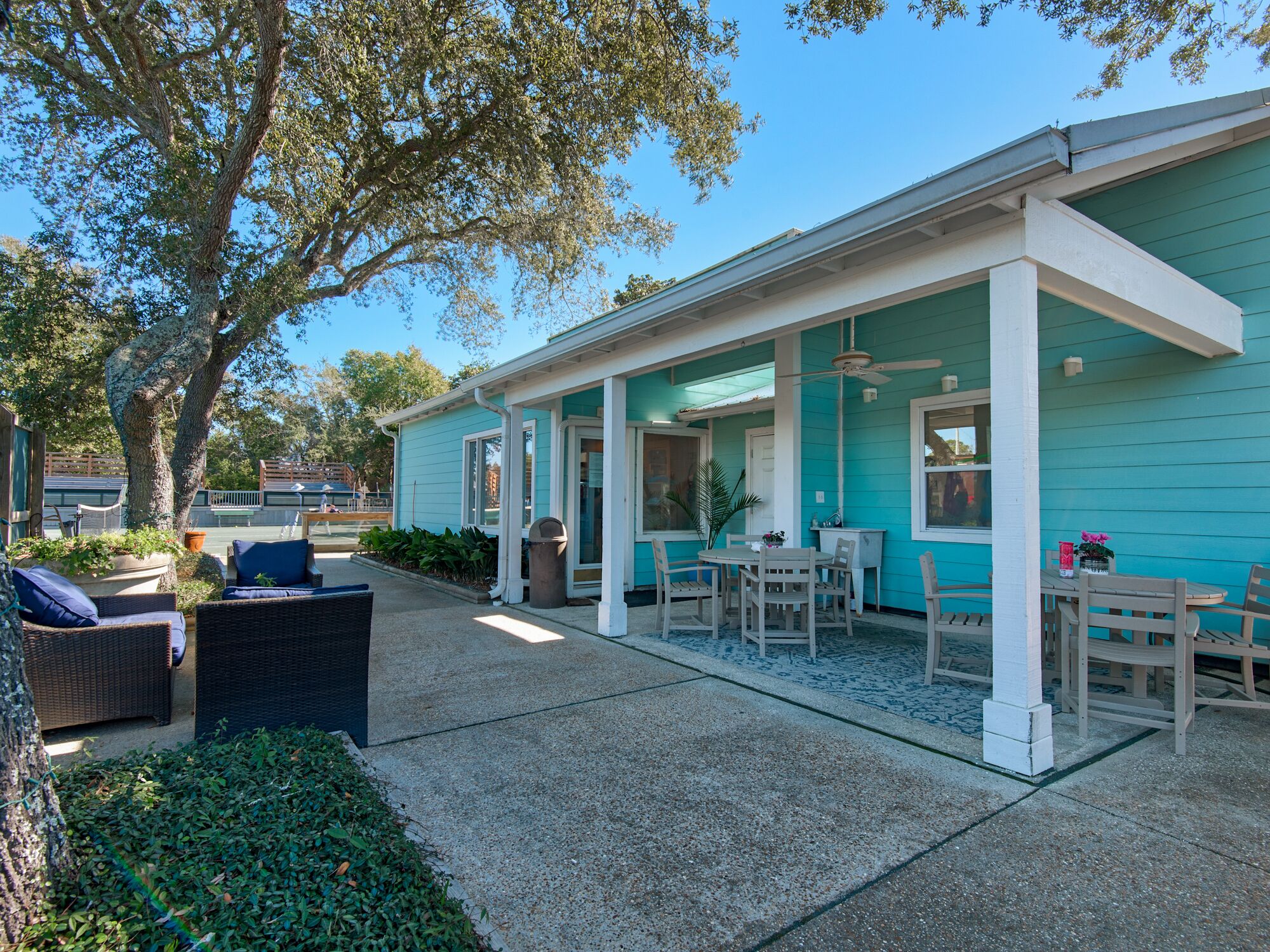 A covered patio area with outdoor seating and a view of the street.