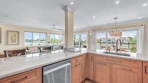 Een moderne keuken met een groot eiland, inbouwapparatuur en uitzicht op de omgeving.