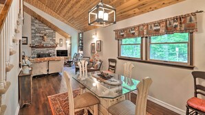 A dining area with a glass table, wooden chairs, and a rustic ceiling. - Relaxing Eagle Rock Resort Home - 1 Block to Lake! (Hazleton)