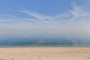 A beach with a clear sky and calm water. - Amazing Rocky Point Retreat Overlooking the Sound! (Rocky Point)