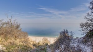 Een strand met heldere lucht, zandstrand en schaarse begroeiing.