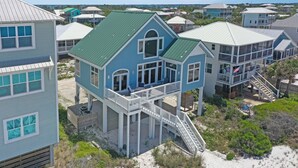 A coastal house with a green roof, multiple balconies, and a staircase leading to a deck. - Sunroom, Quiet Neighborhood, Gulf Front, Private Dune Walkover ~ La Mer (Cape San Blas)