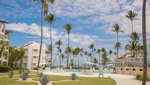 Un resort con piscina, palmeras y edificios modernos.