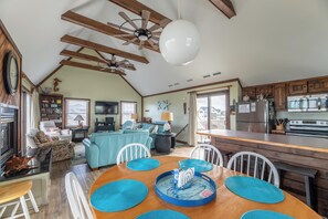 A spacious living area with a dining table, kitchen, and seating arrangements.