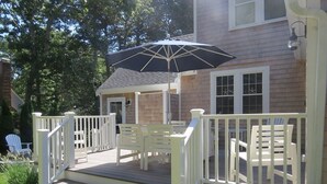 A wooden deck with white railings and a black umbrella. - Close to kid-friendly Ridgevale Beach! (Chatham)