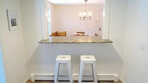 A bathroom with a white vanity, a mirror, and a chandelier. - Close to kid-friendly Ridgevale Beach! (Chatham)