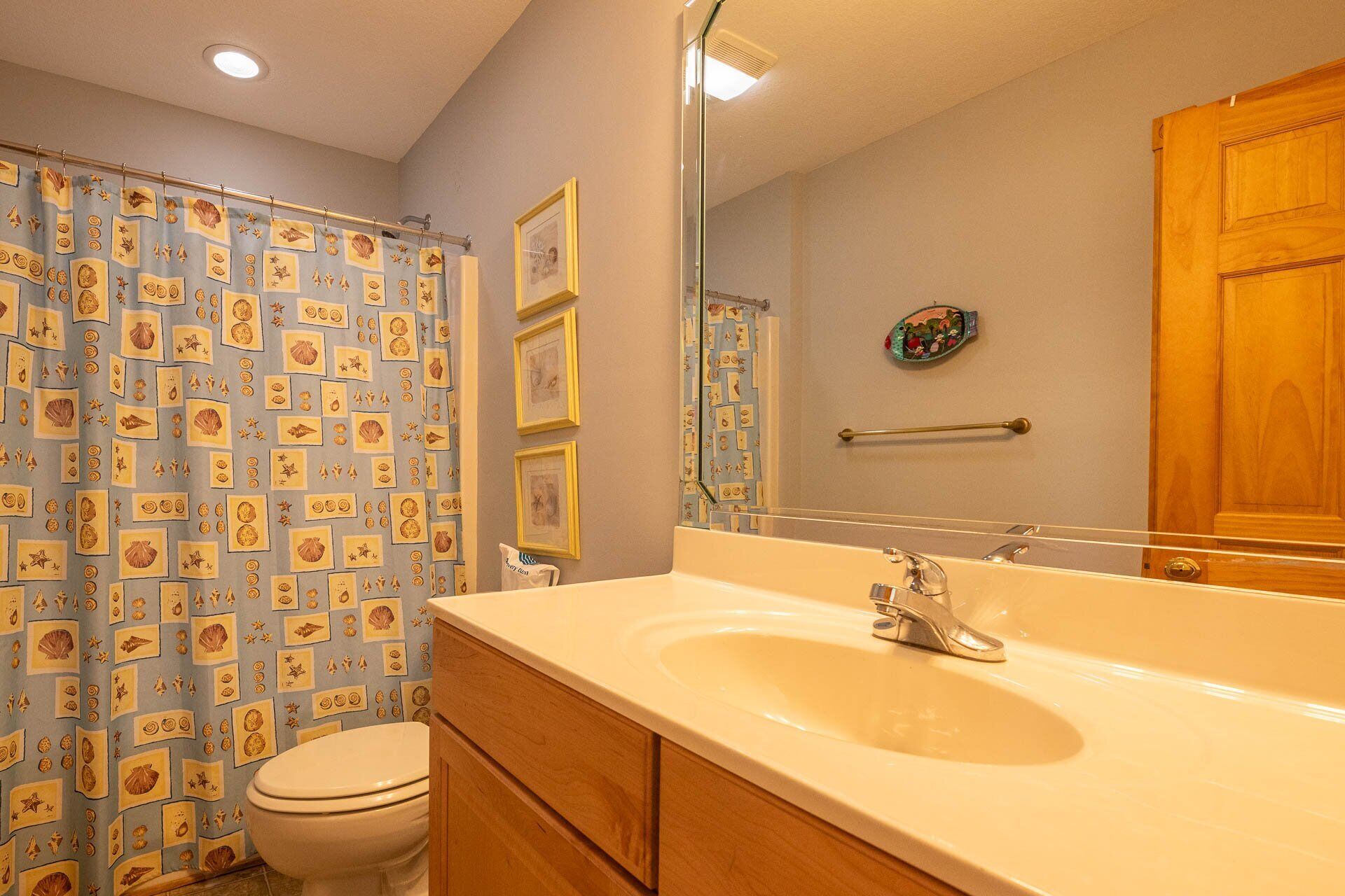 A bathroom with a sink, mirror, and toilet.