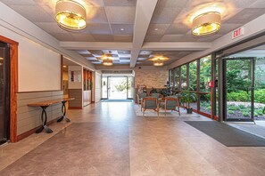 A spacious lobby with a checkered ceiling, a reception desk, seating area, and large windows offering a view of the outdoors. - Cute, cozy 2 bedroom oceanfront condo with free WiFi, a great ocean view, and awesome amenities including indoor/outdoor pools and a game room located uptown! (Ocean City)