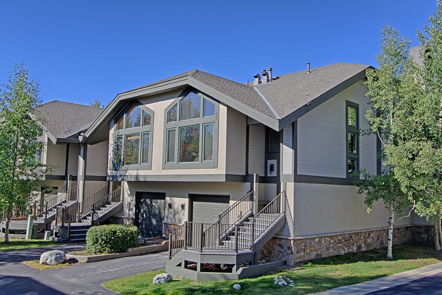 A two-story residential building with a front entrance, a covered porch, and a staircase leading to the second floor.