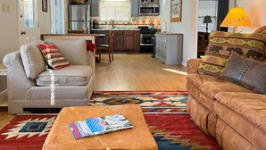 Un salon chaleureux avec un canapé, une table basse et un tapis à motifs.