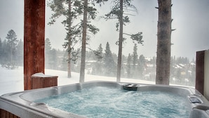 A hot tub with a view of snow-covered trees and houses. - Ski-In/Ski-Out Luxury Condo - Private Hot Tub! (Breckenridge)