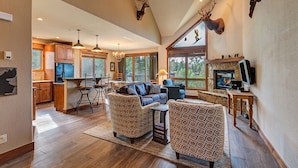 A spacious living area with a fireplace, a dining area, and a kitchen. - Ski-In/Ski-Out Luxury Condo - Private Hot Tub! (Breckenridge)